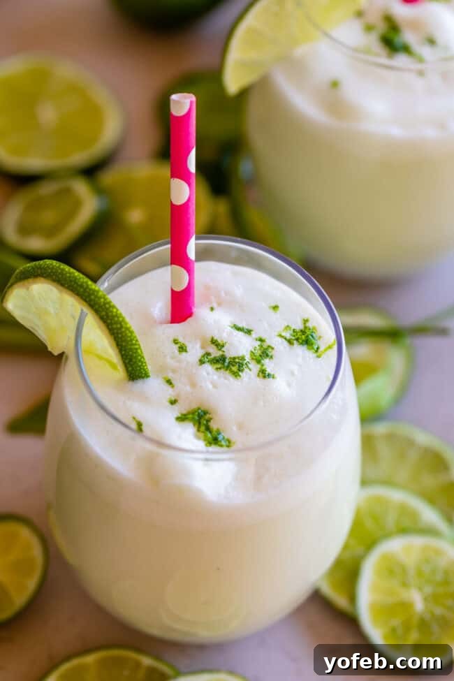 Creamy Brazilian Lemonade Recipe 6 A beautifully garnished glass of Brazilian Lemonade, featuring delicate lime zest and a charming pink polka dot straw.