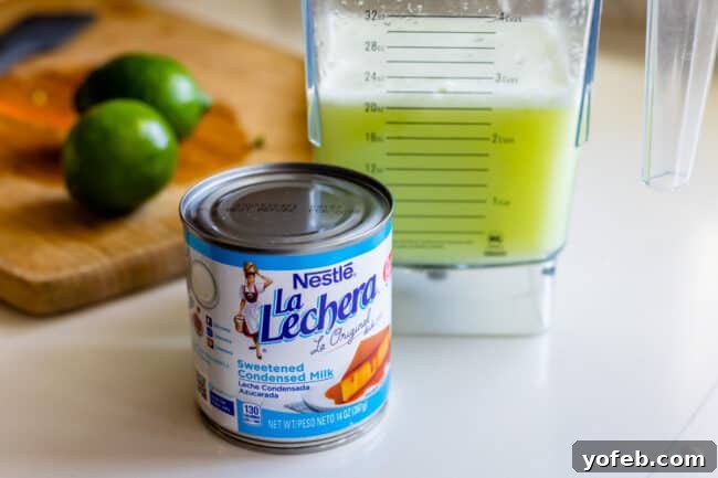 Creamy Brazilian Lemonade Recipe 8 La Lechera brand sweetened condensed milk with Brazilian Limeade in the background, a key ingredient for the drink's creamy texture.