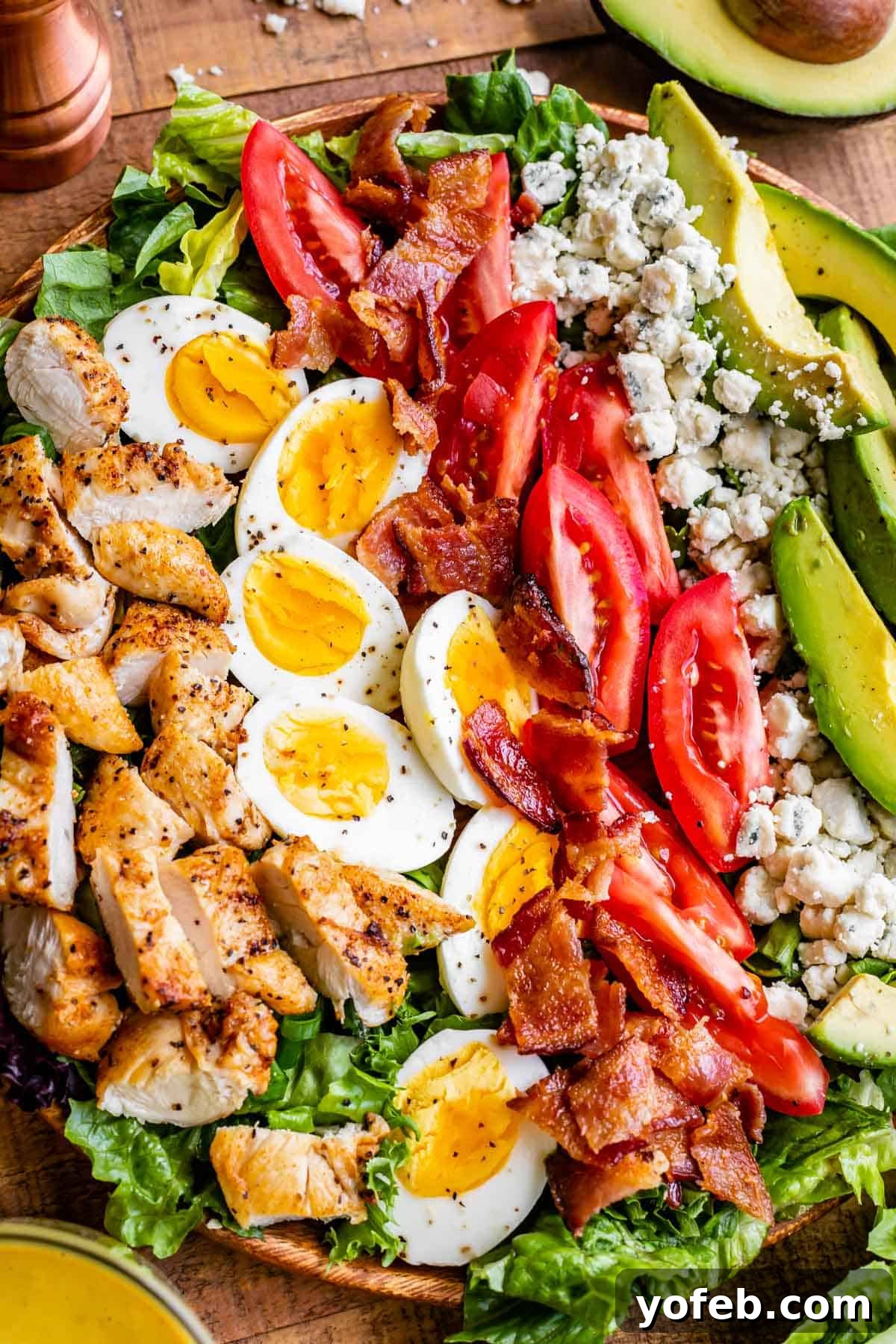 best cobb salad, with ingredients lined up across a wooden plate