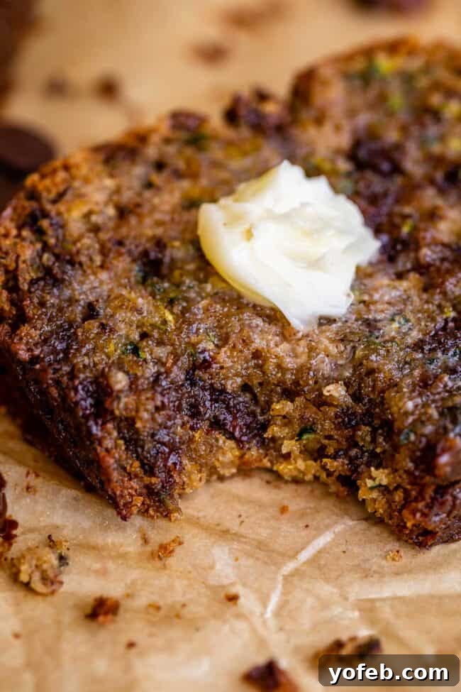 Heavenly Zucchini Bread 26 melting butter on zucchini bread slice with a bite taken out.