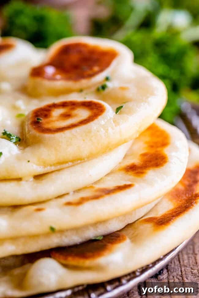 fresh homemade naan bread, stacked up on a plate.
