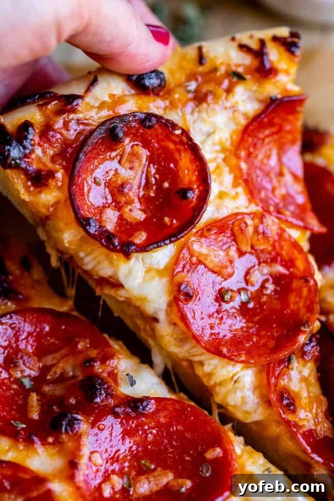 The Ultimate Homemade Pizza Ready When You Are 2 A delectable slice of homemade pepperoni pizza being lifted, showcasing melted cheese and a crispy crust.