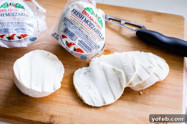 The Ultimate Homemade Pizza Ready When You Are 18 Thinly sliced fresh mozzarella cheese on a cutting board, ready for pizza topping.