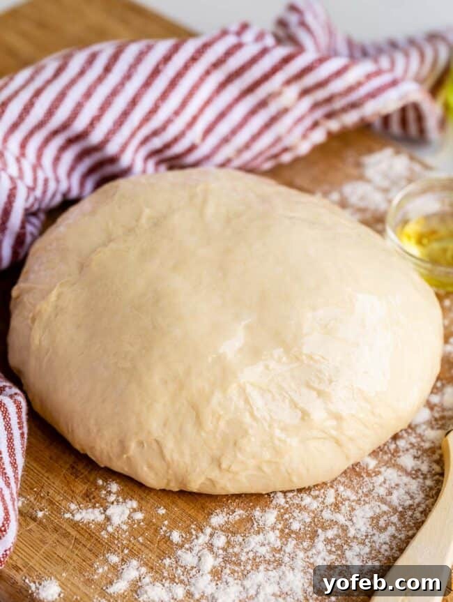 Foolproof Pizza Dough for Newbies 4 quick pizza dough on a cutting board with rust colored napkin.