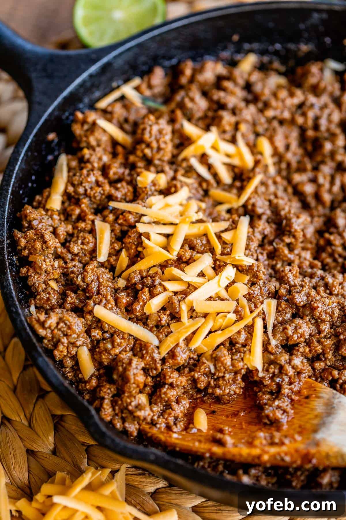 Elevate Your Tacos with Homemade Seasoning 13 Taco meat topped with melting shredded cheddar cheese in a cast iron skillet, ready for serving.