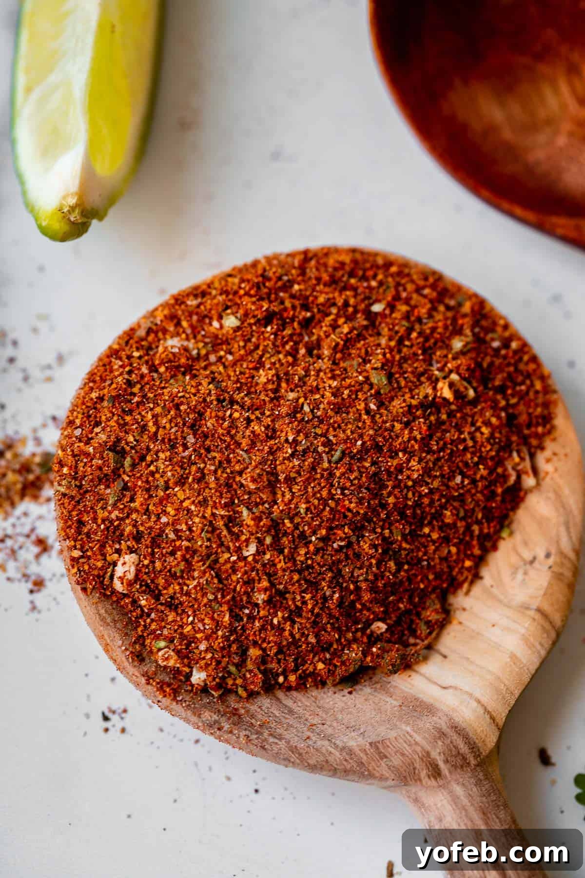 Elevate Your Tacos with Homemade Seasoning 7 Homemade taco seasoning displayed on a wooden spoon resting on a kitchen counter.