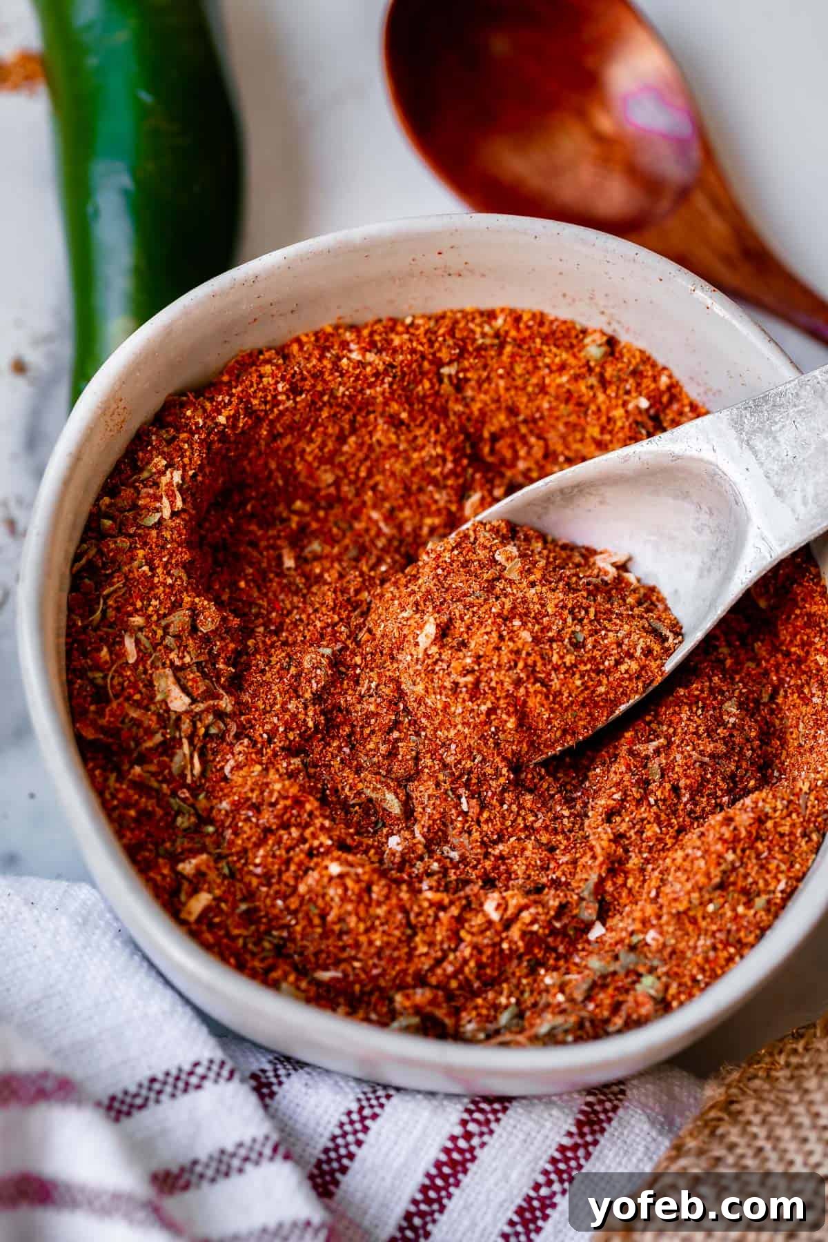 Elevate Your Tacos with Homemade Seasoning 10 Homemade taco seasoning recipe in a white bowl with a metal spoon, ready to be used or stored.