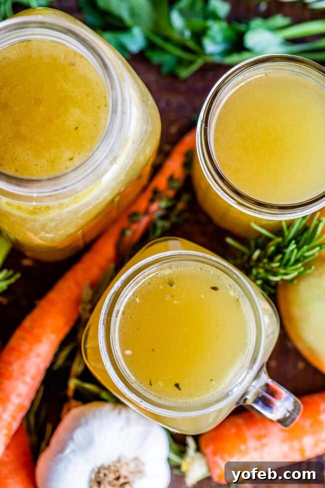 Homemade Turkey Stock: Ready for Storage. Learn how easy it is to make Turkey Stock from the bones of your Thanksgiving turkey! All you need is a picked over turkey carcass and some vegetables and herbs that you probably already have on hand from cooking your turkey. You are going to love using this flavorful turkey stock in your next soup! #turkey #stock #fromcarcass #recipe #forgravy #uses #fromneckandgiblets #homemade #slowcooker #crockpot #soup #howtomake #leftovers turkey stock recipe showing stock inside Mason jars, top view.