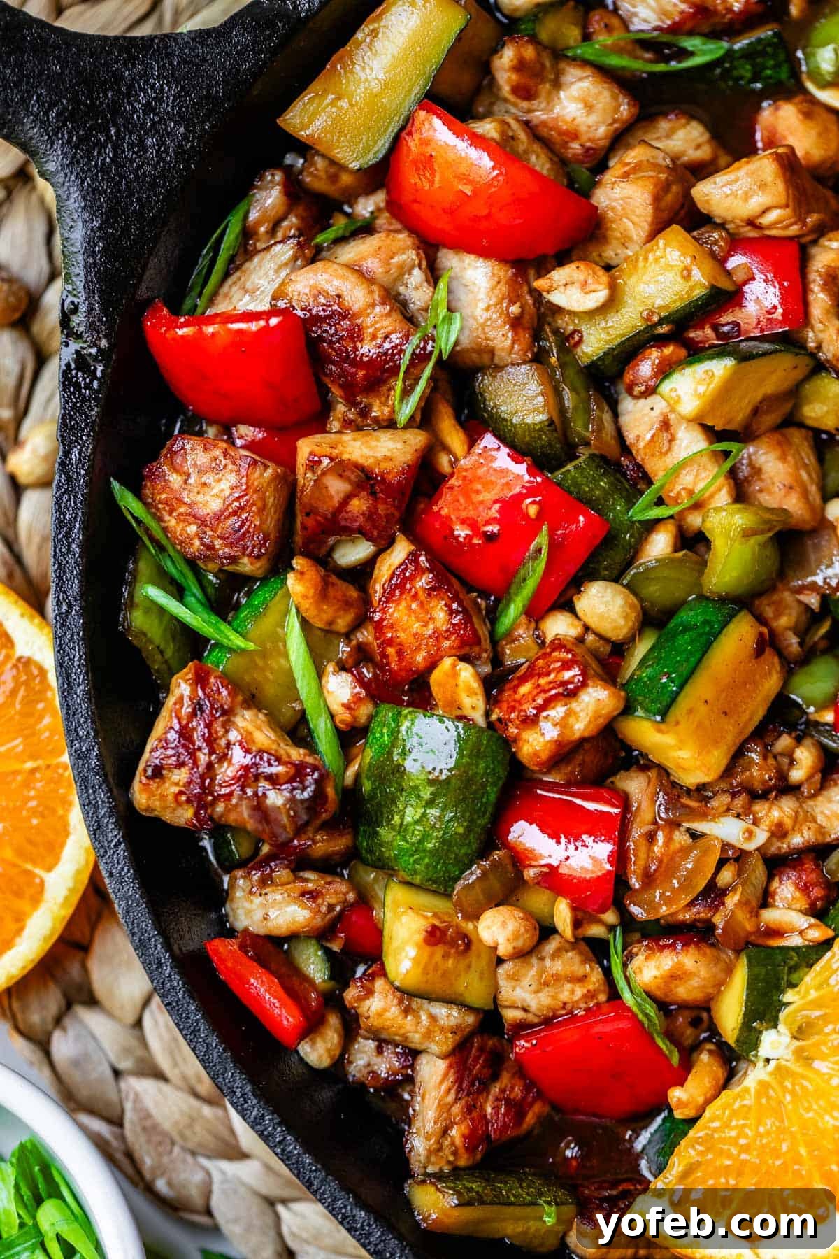 Szechuan Kung Pao Chicken 17 Kung Pao chicken generously topped with fresh green onions in a cast iron skillet, ready to be served.