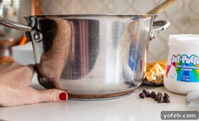 Mom's Effortless Fudge 11 A heavy-bottom pot, with a thumb demonstrating its thick base, highlighting the importance of proper cookware for fudge making.