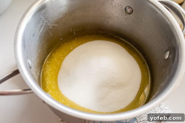 Mom's Effortless Fudge 15 Granulated sugar being carefully poured into the center of a pot containing melted butter, avoiding contact with the pan's sides.