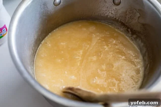 Mom's Effortless Fudge 17 A full rolling boil in a pot containing the sugar, butter, and evaporated milk mixture, with bubbles actively rising from the center.