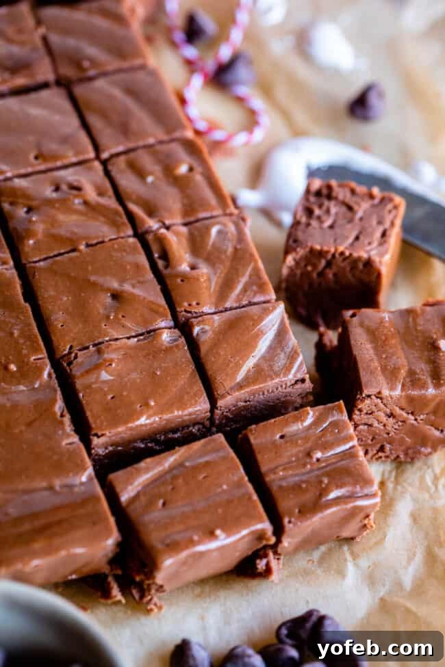 Mom's Effortless Fudge 3 Perfectly cut squares of marshmallow fluff fudge arranged neatly on parchment paper, ready for gifting or enjoying.