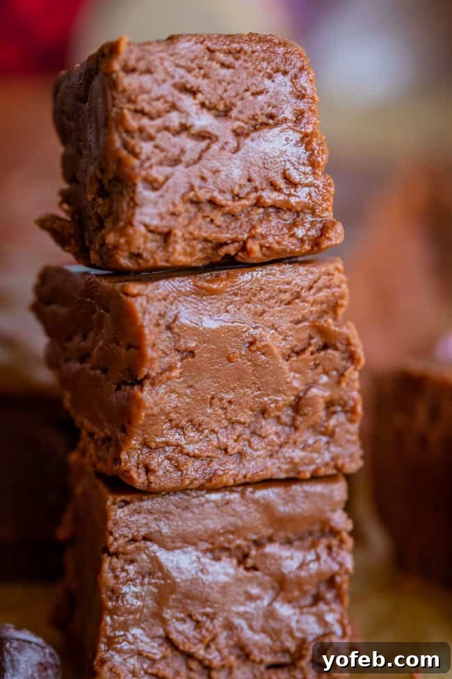 Mom's Effortless Fudge 31 Neatly stacked squares of marshmallow creme fudge, showcasing their rich texture and perfect consistency.