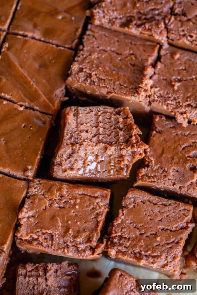 Mom's Effortless Fudge 32 An overhead view of fluffy fudge with a small bite taken out of one piece, tempting viewers with its creamy texture.