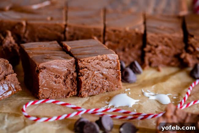 Mom's Effortless Fudge 8 Creamy marshmallow cream fudge, elegantly cut into squares and nestled on parchment paper, adorned with festive baker's twine.