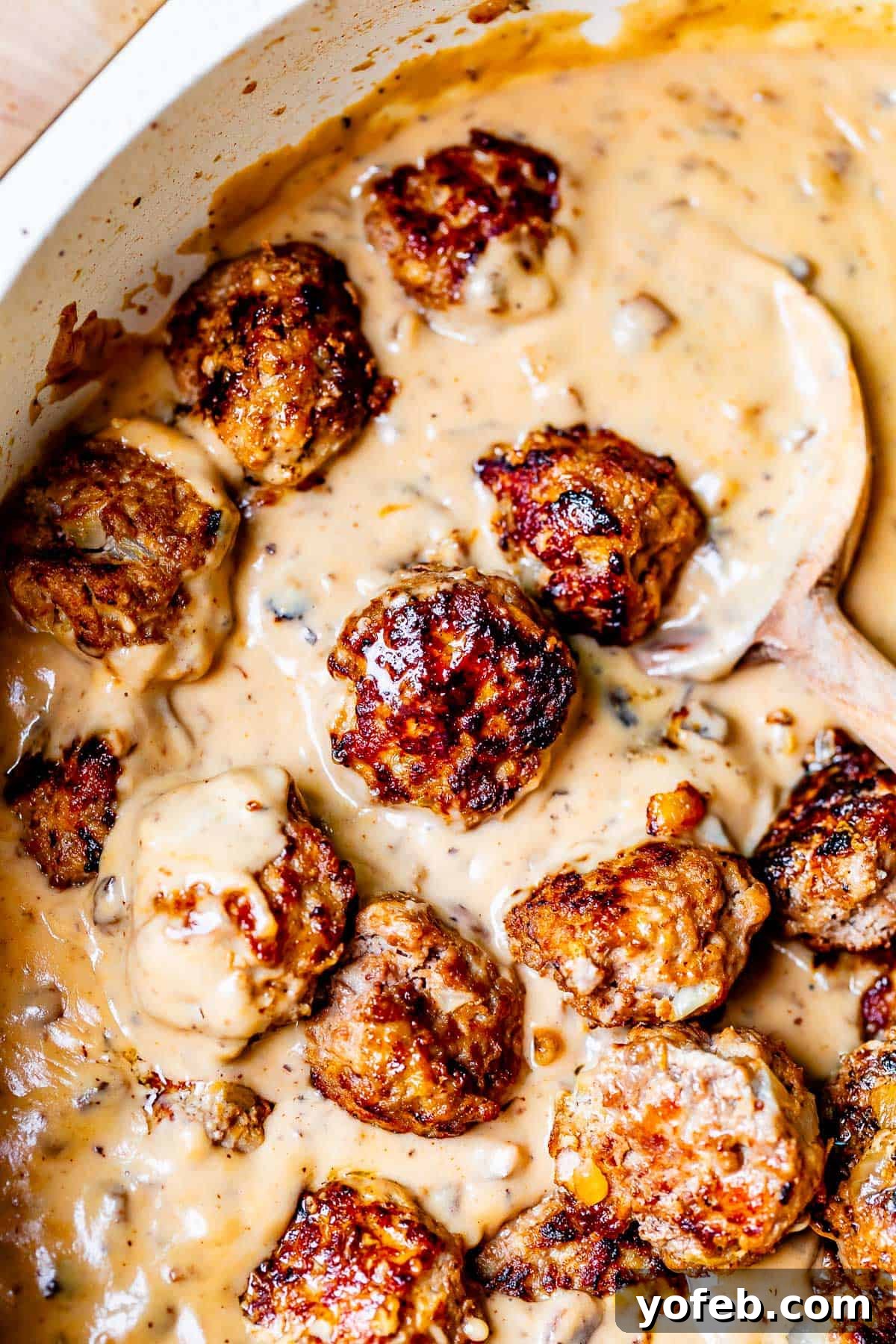 Grandma Prudy's Timeless Swedish Meatballs 2 Looking down into a skillet filled with creamy brown gravy, and Swedish Meatballs, ready to be served.