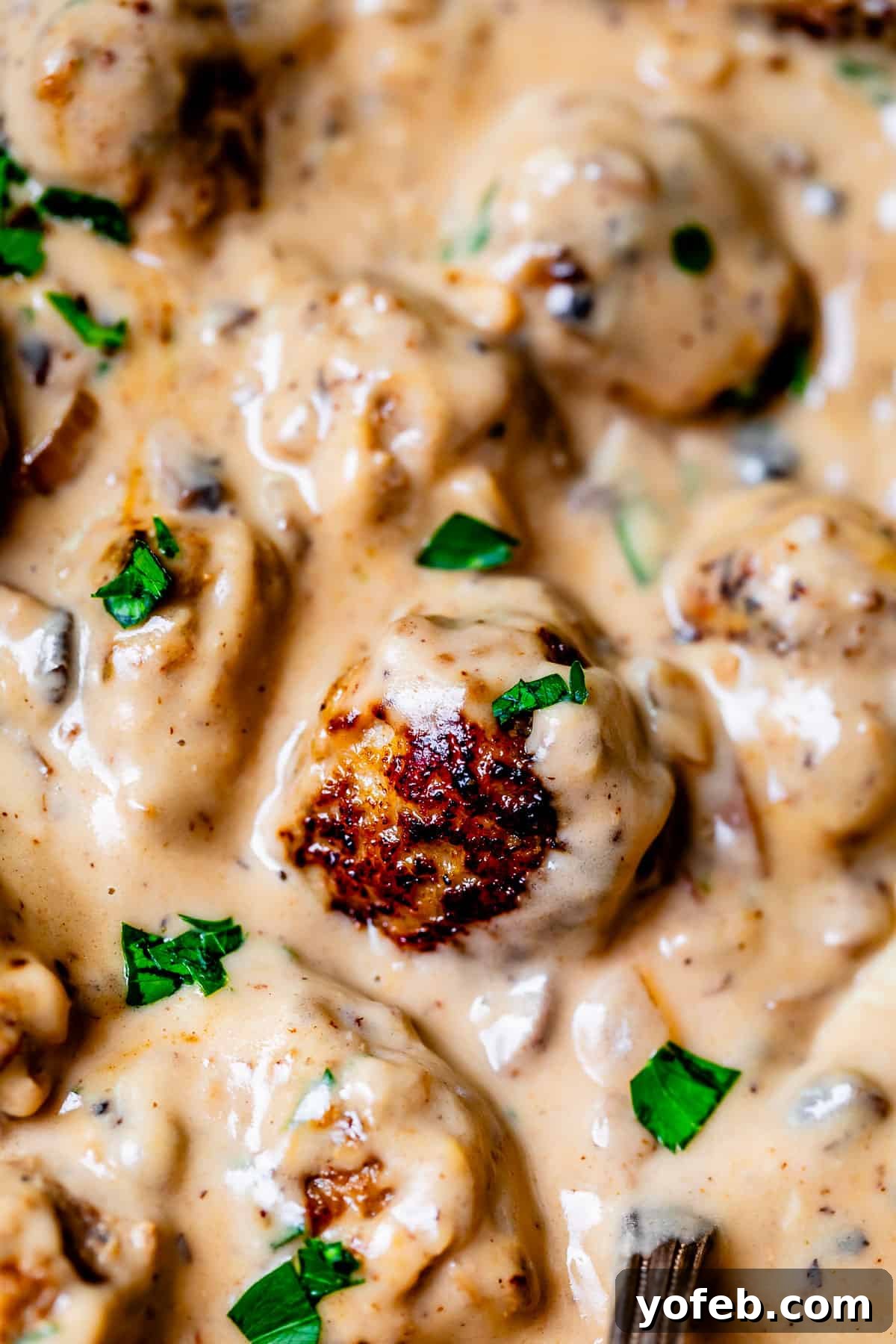 Grandma Prudy's Timeless Swedish Meatballs 23 A rich, creamy, and velvety Swedish meatball sauce beautifully covering several tender meatballs in a deep dish.