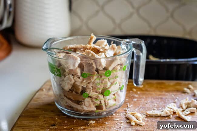 Effortless Creamy White Chicken Chili 10 Shredded rotisserie chicken in a glass measuring cup, ready for the chili.