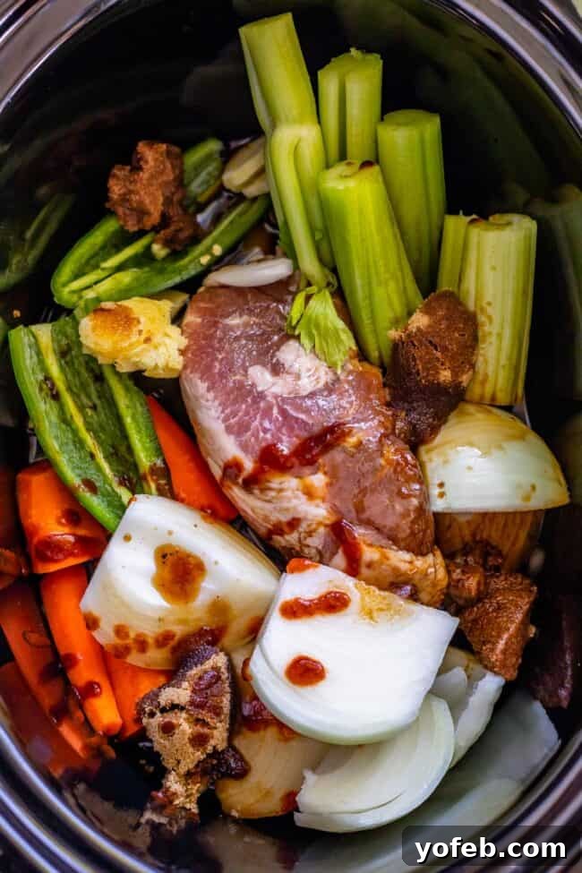 Slow Cooker Pork Ramen Deep Flavor Zero Fuss 10 pork shoulder, celery, onion, carrots, jalapeno in a crock pot from over head