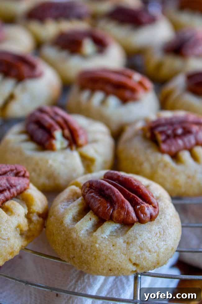 Freshly baked butter pecan cookies cooling on a wire rack, ready to be enjoyed.