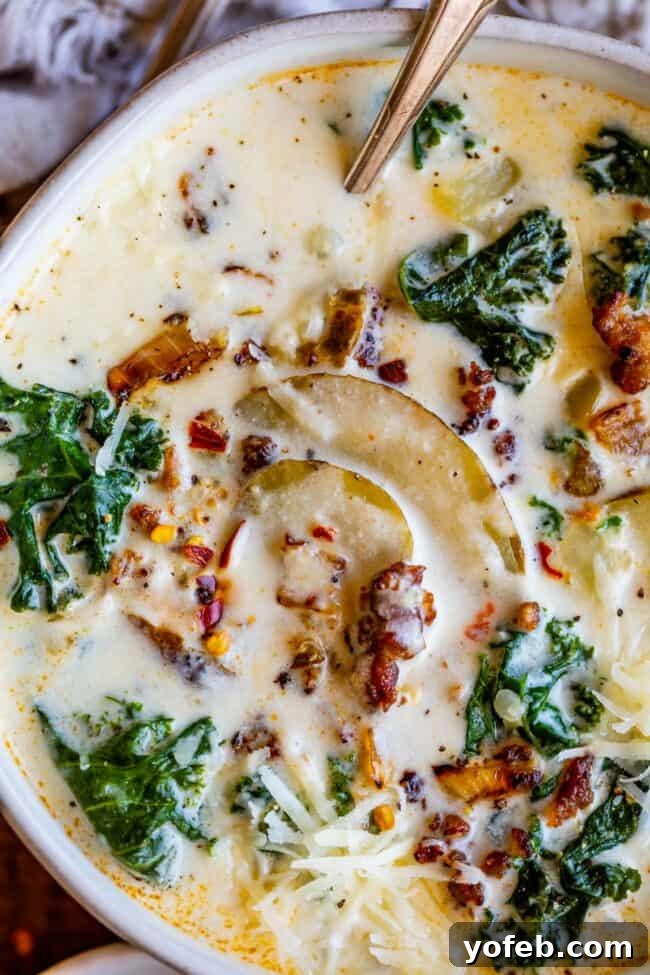 Homemade Zuppa Toscana Copycat with Sausage, Potato, and Kale A steaming bowl of Zuppa Toscana with Italian sausage, potatoes, and kale, garnished with fresh parsley.
