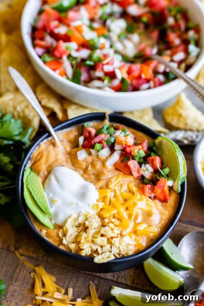 Creamy Chicken Enchilada Soup (Chili's Copycat Recipe) from The Food Charlatan. This dreamy Creamy Chicken Enchilada Soup tastes like the kind at Chili's, only better! It is a simple soup that has a unique flavor thanks to Masa Harina (corn flour). There are no veggies in the soup; instead you make Pico de Gallo and serve it as a generous topping! It's one of my all time favorite soups! #chicken #dinner #recipe #easy #enchilada #enchiladasoup #chickensoup #creamy #cheesy #stovetop #Chilis bowl of chicken enchilada soup in front of a bowl of pico de gallo.