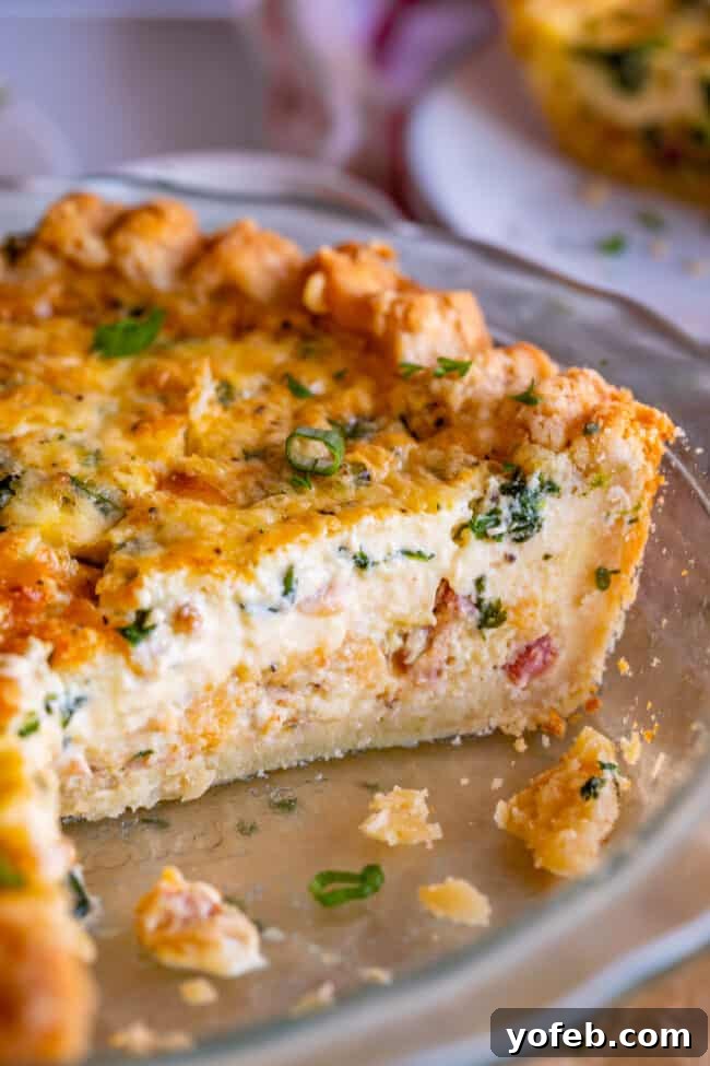 Effortless Bacon and Spinach Quiche 23 A side view of a beautifully baked quiche in a clear glass pie pan, highlighting its golden crust and rich filling.