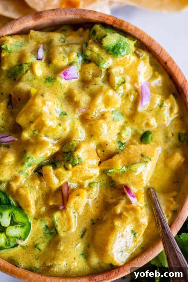 Flavorful Chicken Curry Made Easy 2 easy curry recipe in a wooden bowl topped with red onion and jalapeno.