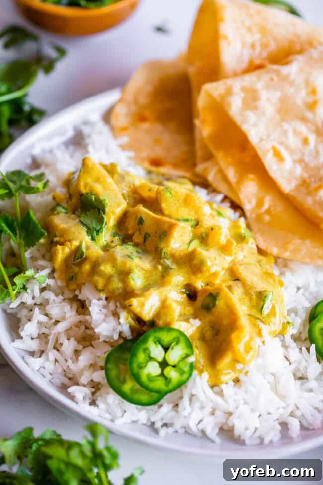 Flavorful Chicken Curry Made Easy 20 Indian curry recipe on a white plate with rice, roti, and garnishes.