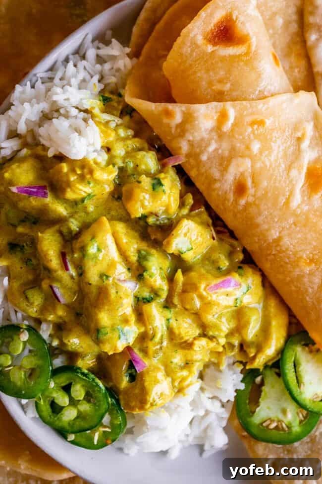 Flavorful Chicken Curry Made Easy 6 Indian chicken curry recipe on top of rice with roti on a white plate.