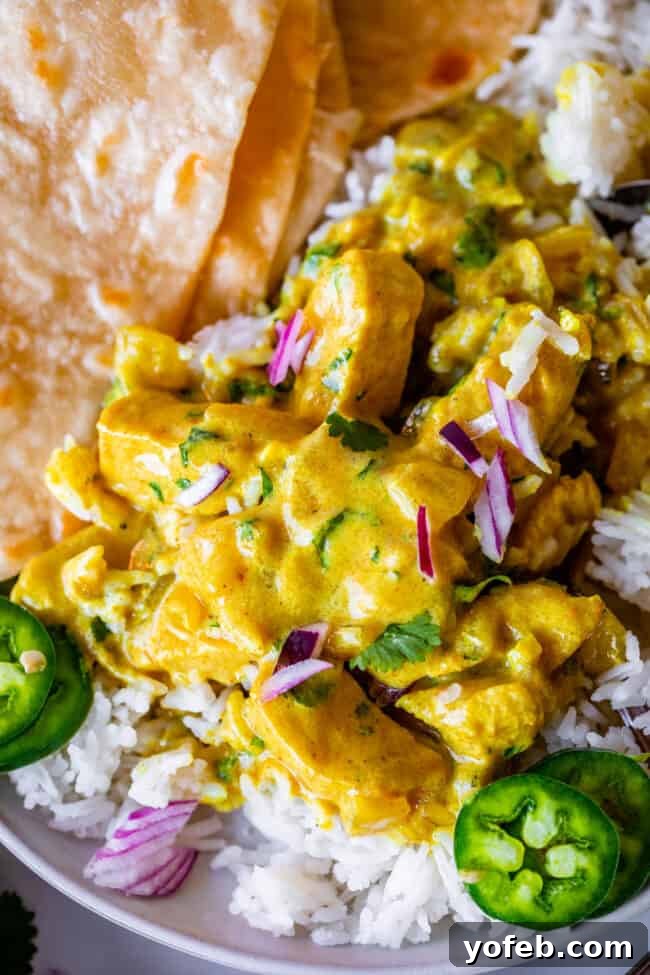 Flavorful Chicken Curry Made Easy 7 Indian chicken curry piled on top of rice on a plate with roti.