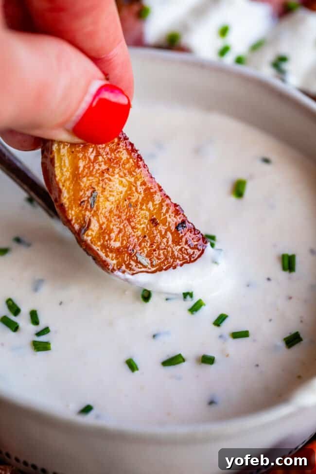 Fiery Homemade Horseradish Sauce 14 dipping a roasted potato into horseradish sauce.