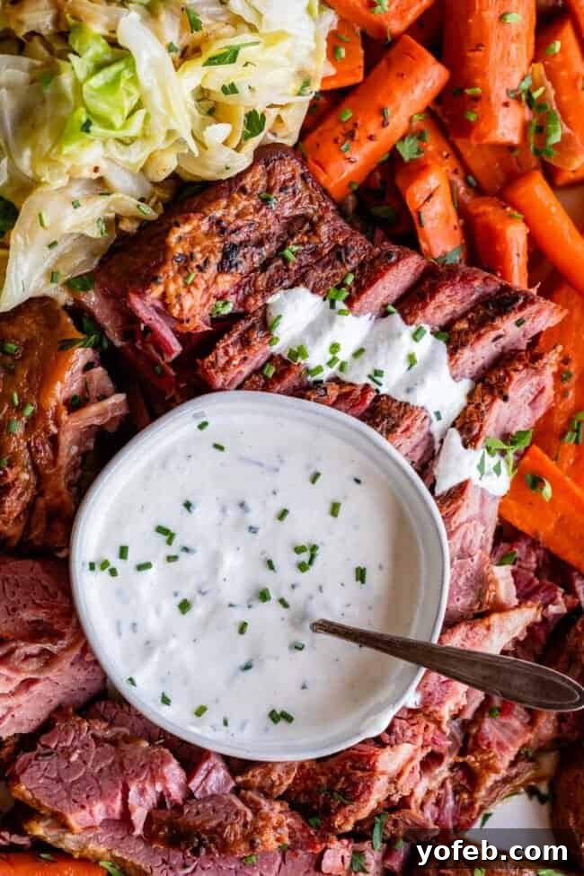 Fiery Homemade Horseradish Sauce 15 creamy horseradish sauce in a bowl with corned beef and cabbage around it.