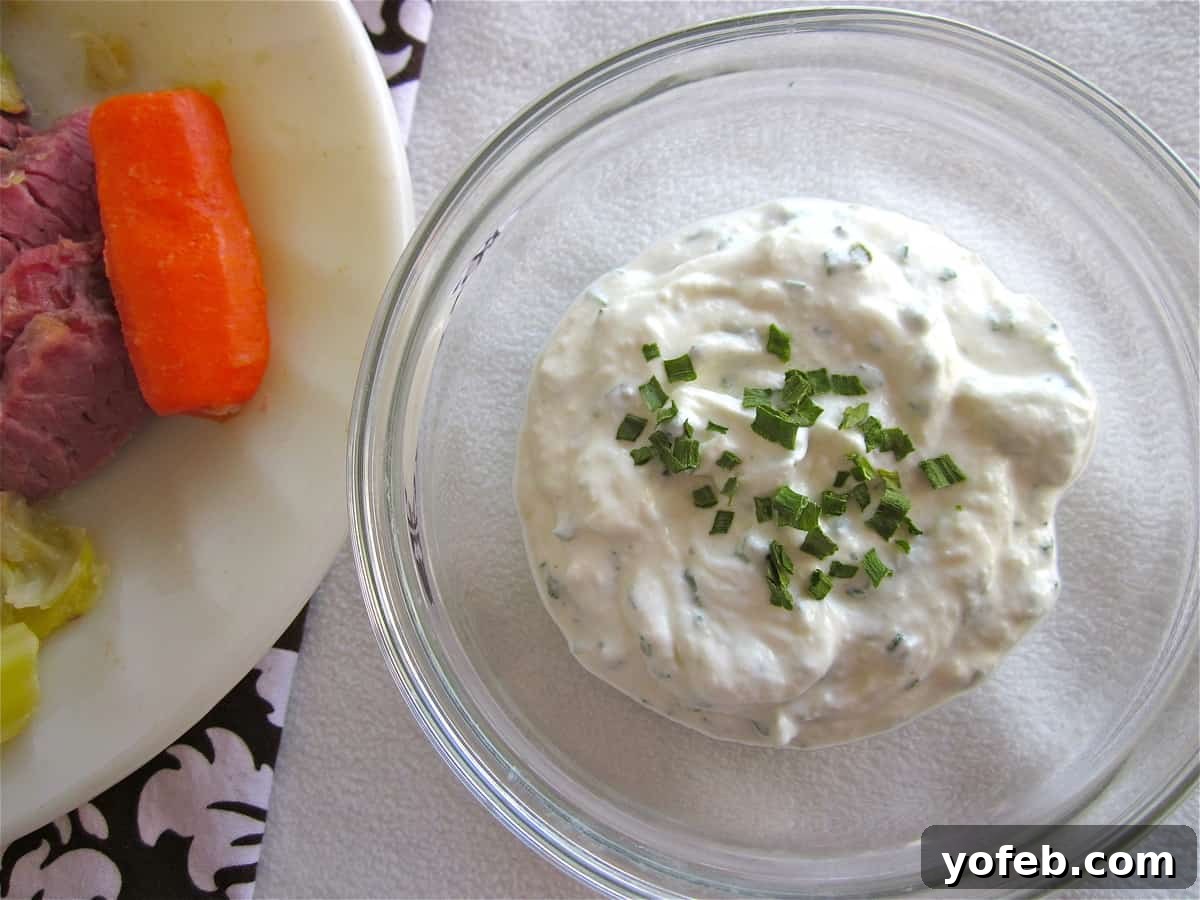 IMG_2457 an old photo of a bowl of horseradish sauce near a plate of corned beef, cabbage, and carrots.