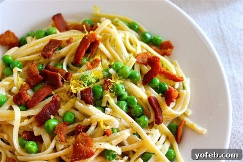 Zesty Lemon Bacon Pea Pasta 5 Creamy pasta with lemon zest, crispy bacon pieces, and bright green peas, artfully arranged in a serving bowl.