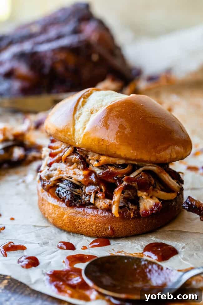 Melt In Your Mouth Pulled Pork Slow Cooker Or Oven 25 pulled pork made in the oven on a hamburger bun with bbq sauce.