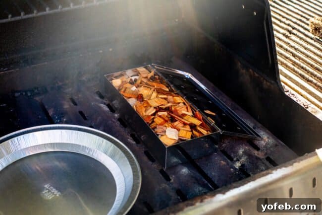 Smoky Perfection: The Ultimate Pulled Pork 13 wood chips in a smoker box set on the heat plates of a grill.