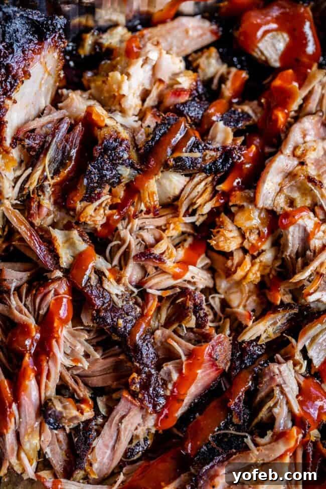 Smoky Perfection: The Ultimate Pulled Pork 4 close up of smoked pulled pork drizzled with bbq sauce.