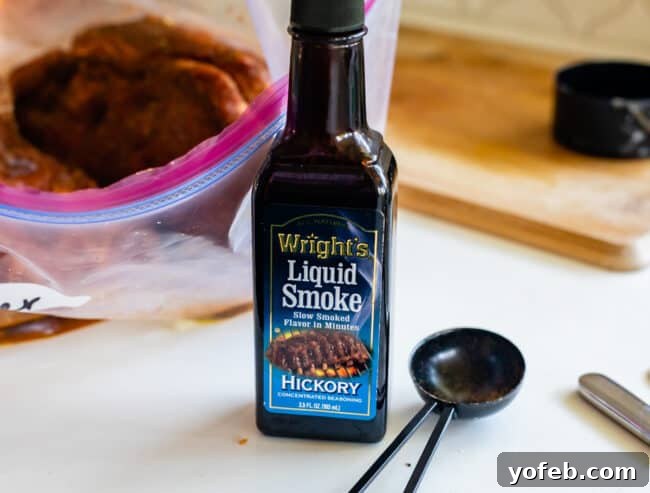 Effortless Homemade Barbecue 12 bottle of liquid smoke on white countertop with tablespoon.
