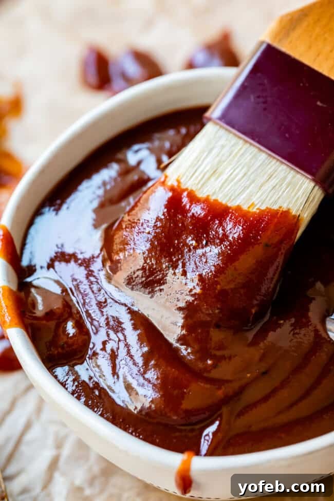 Effortless Homemade Barbecue 13 white brush dipping into a white bowl full of barbecue sauce.