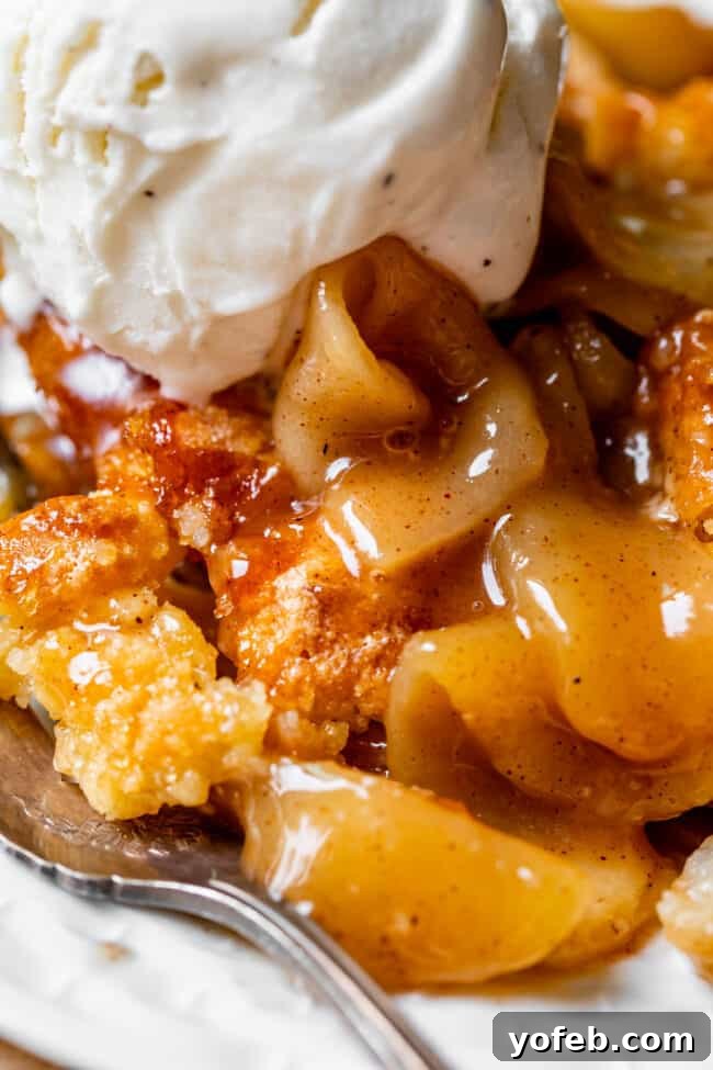 Effortless Homemade Apple Cobbler 6 A close-up shot of apple cobbler with a generous scoop of melting vanilla ice cream on top.