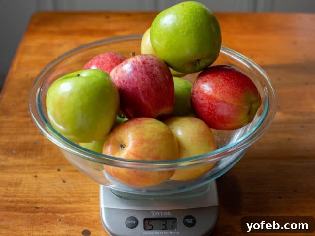 Effortless Homemade Apple Cobbler 9 A variety of apples in a clear glass bowl on a scale, weighing exactly 5 pounds.