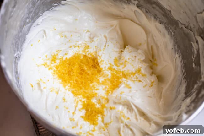 Sunshine Lemon Delight 11 Cream cheese filling for lemon dessert in a bowl, visibly mixed with lemon zest for added flavor.