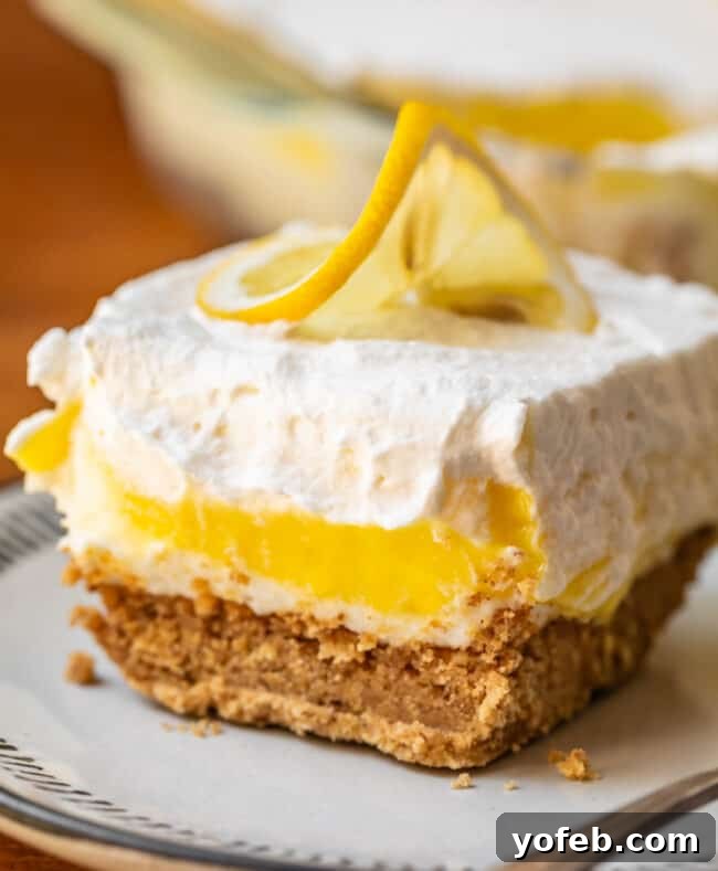 Sunshine Lemon Delight 3 A single slice of Lemon Lush Dessert on a white plate, showing the distinct layers, ready to be enjoyed.