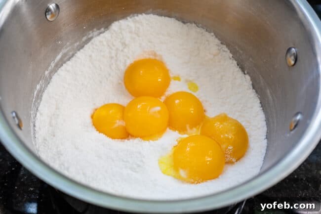 Sunshine Lemon Delight 7 Several vibrant egg yolks mixed with dry lemon pudding mix in a saucepan.