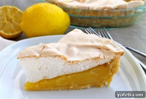 Seriously Zesty Lemon Meringue Pie 5 A perfectly portioned slice of Lemon Meringue Pie, revealing layers of crisp meringue, tangy lemon filling, and a flaky crust.