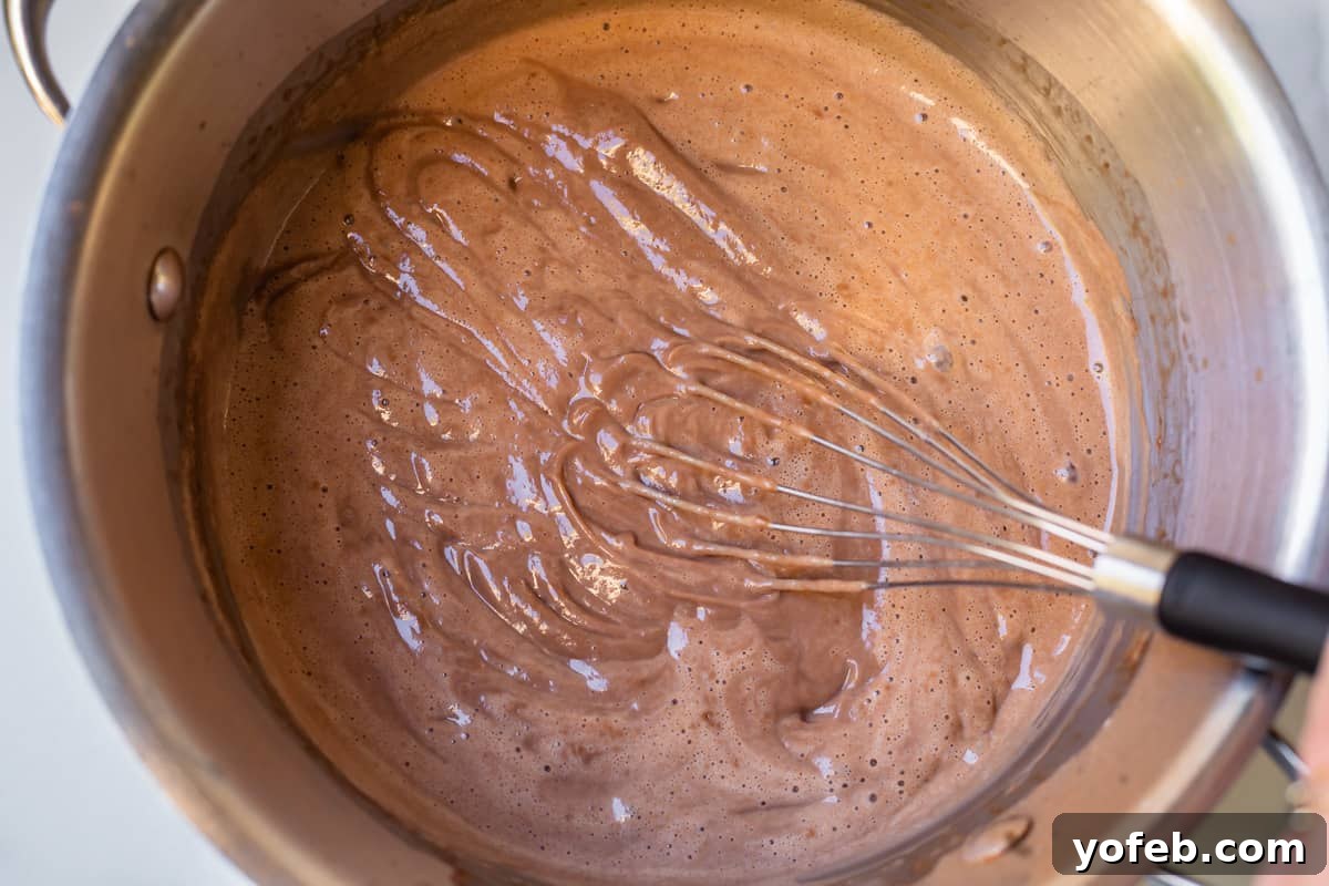 Decadent Chocolate Cream Pie Perfection 19 Finished chocolate pudding in a pot, with whisk marks clearly visible on the surface, indicating perfect consistency.
