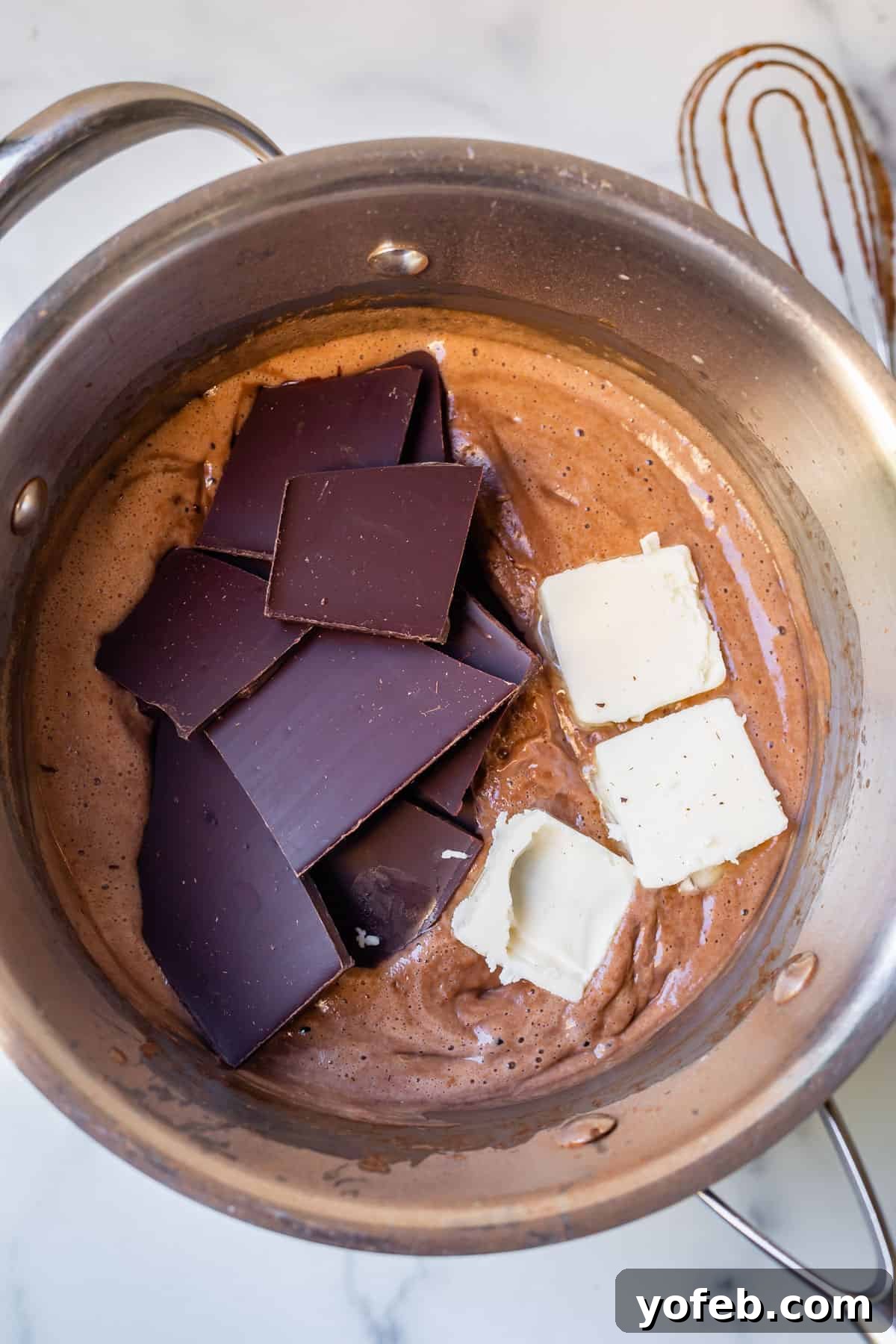 Decadent Chocolate Cream Pie Perfection 20 An overhead shot showing chopped semi-sweet chocolate bars and chunks of butter being added to the hot chocolate pudding in the pot.