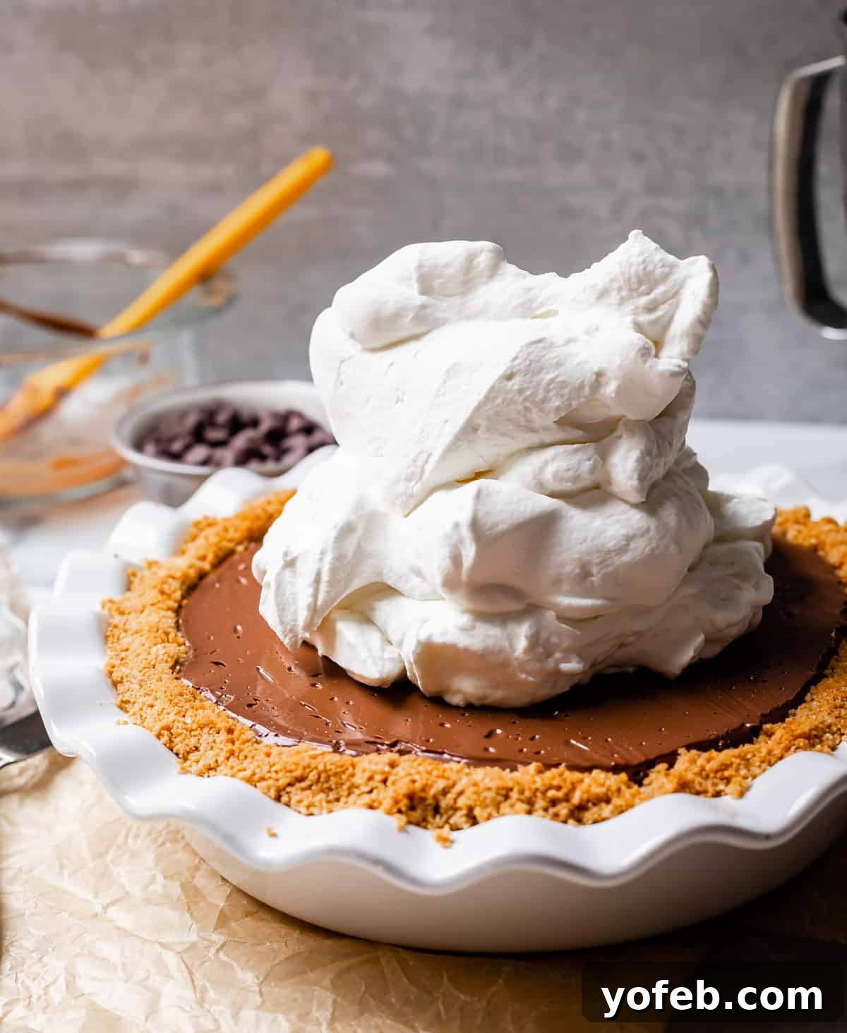 Decadent Chocolate Cream Pie Perfection 29 A generously piled dome of whipped cream topping a rich chocolate pie, creating an inviting dessert.